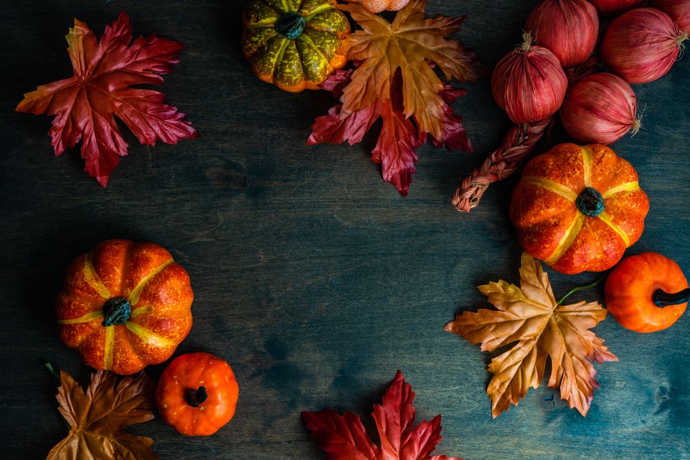 Top view of wooden table with pumpkin decorations and leaves