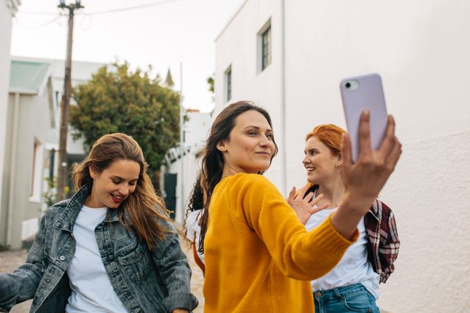 Group of women enjoying dancing on the street and taking a selfie