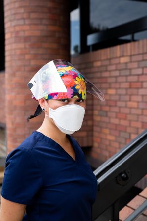Portrait of nurse in front of hospital in PPE looking at camera
