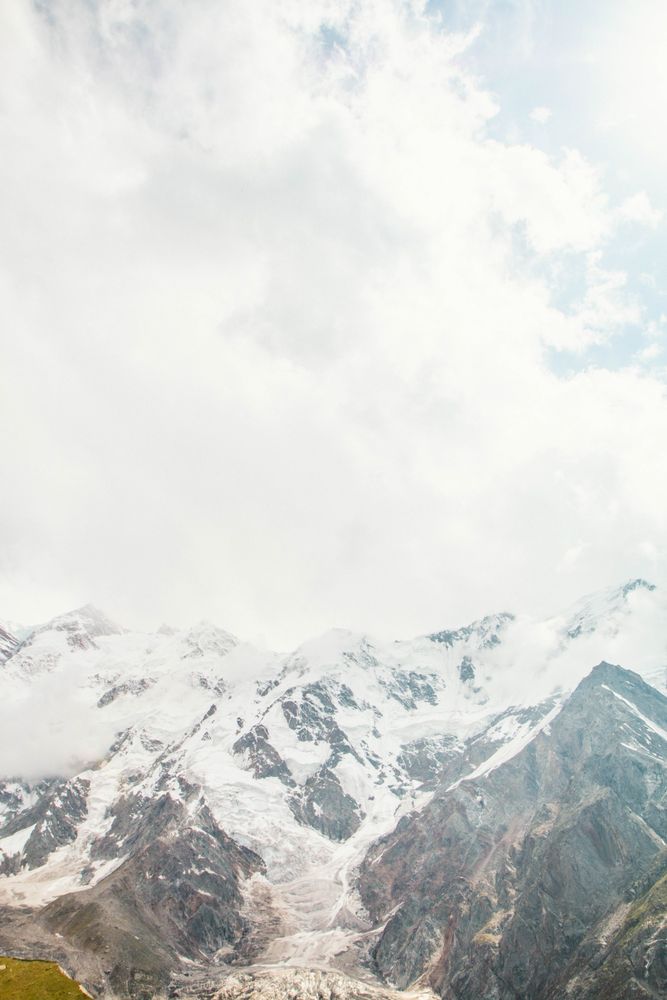 Vertical composition of mountains behind clouds in Fairy Meadows, Pakistan