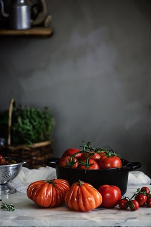 Ripe fresh tomatoes in pot on table