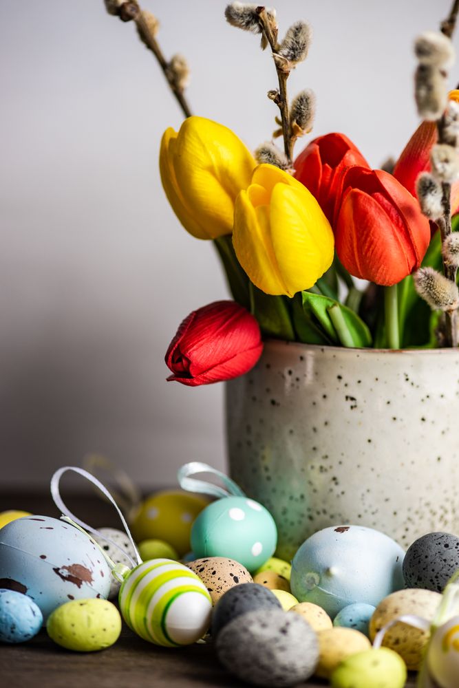 Easter card concept with eggs on table with vase of tulips