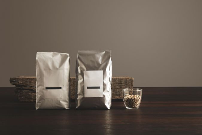Line of two bags of coffee beans and glass of beans