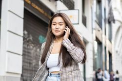 Young Asian woman talking on the phone in the city