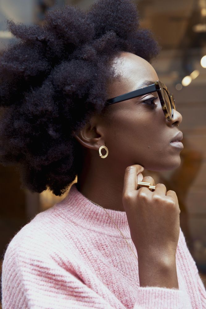 Side view of woman in pink sweater wearing sunglasses