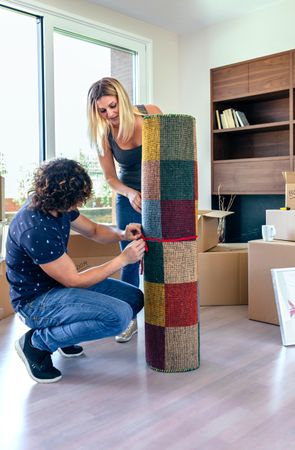 Couple unrolling the carpet