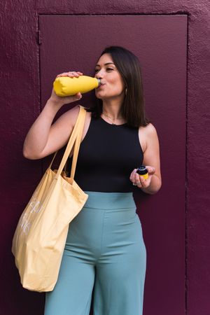 Woman drinking water during stroll in city