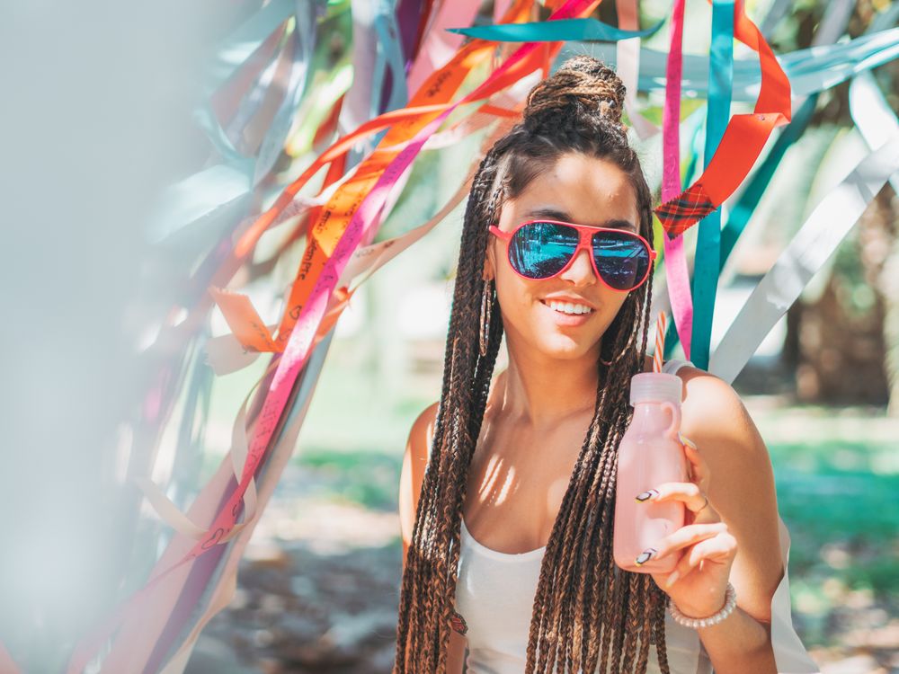 Trendy young woman enjoying beverage during party