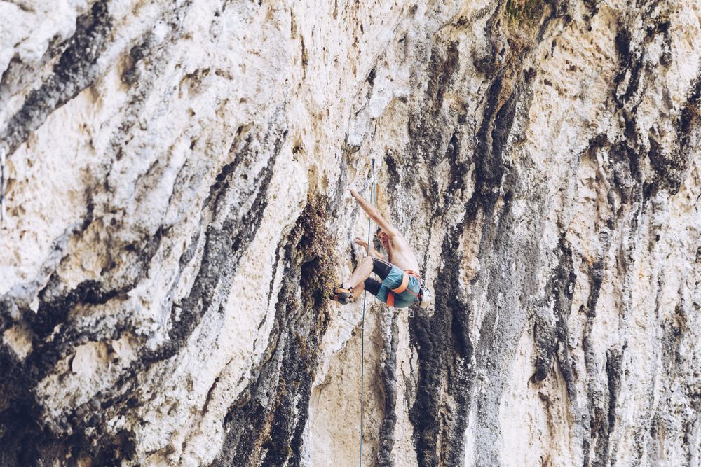 Anonymous man climbing rock