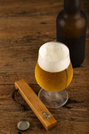 Glass full of cold beer on the wooden table