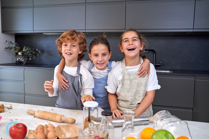 Delighted children making cookie dough