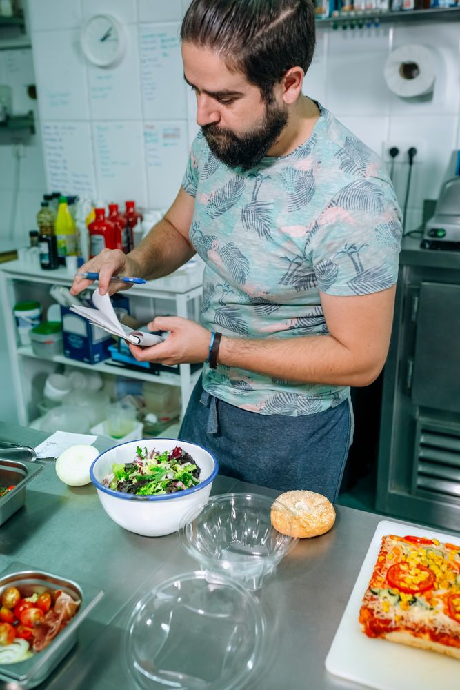 Young cook preparing takeaway orders