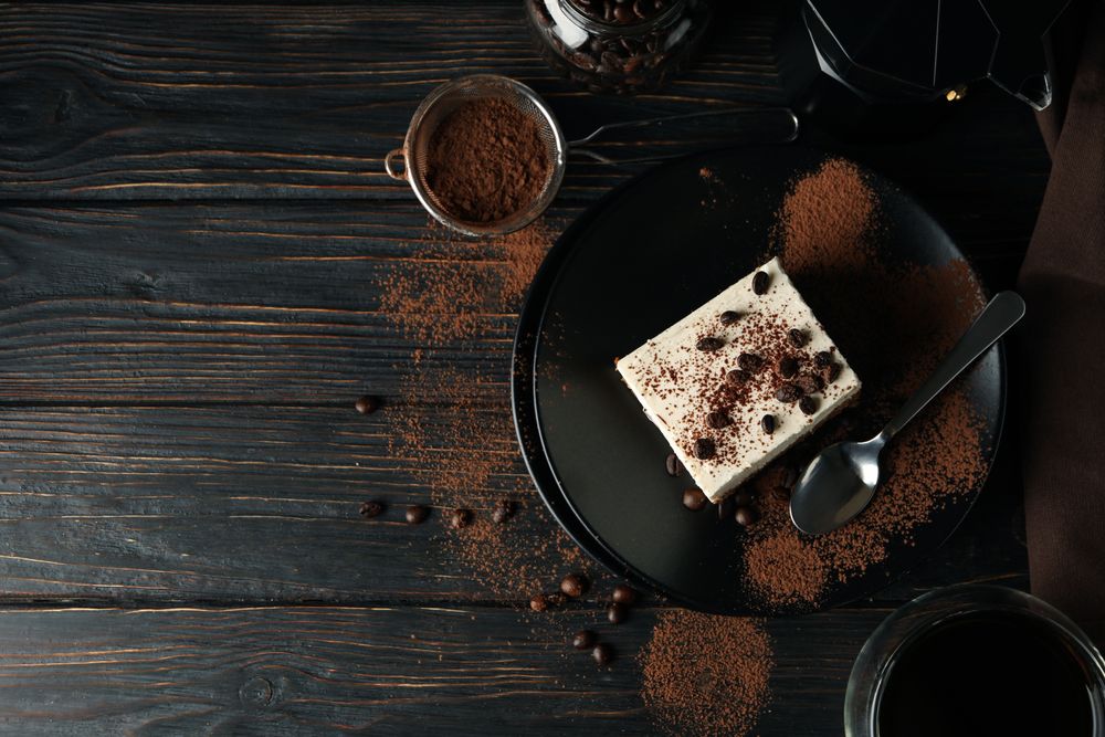 Composition with tasty tiramisu and coffee on wooden background