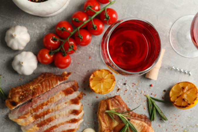 Composition with fried steaks, wine and vegetables. Grilled food