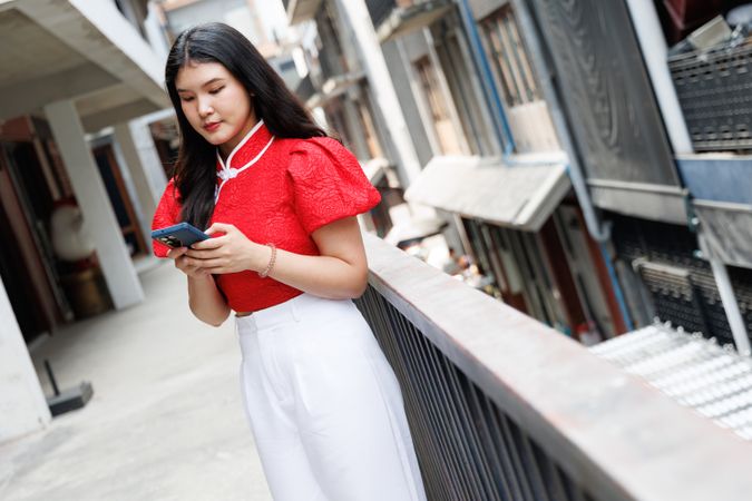 Portrait of Asian person in Chinese New Year costume talking on mobile phone