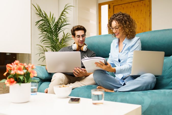 Happy couple using laptop while working on project at home