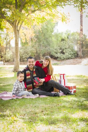 Family Enjoying Christmas Gifts in the Park Together