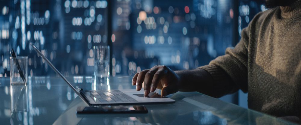 Close Up Of Successful Black Businessman Working on Laptop in Big City Office Late at Night.