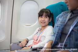 Female child sitting at window seat in airplane 4Ax1Y5