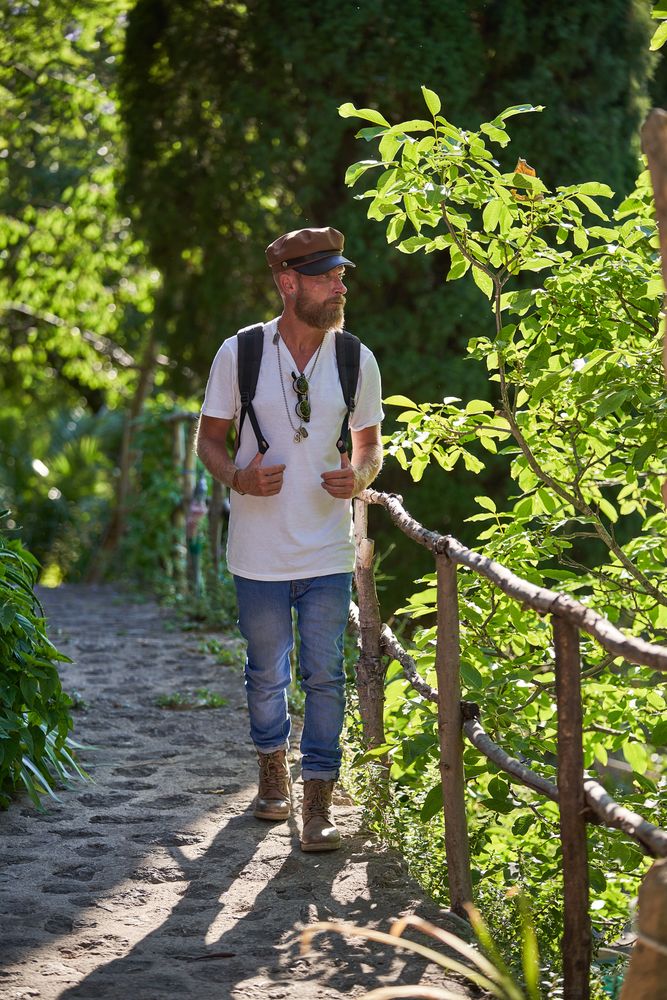 Mature man walking on fenced pathway in woods