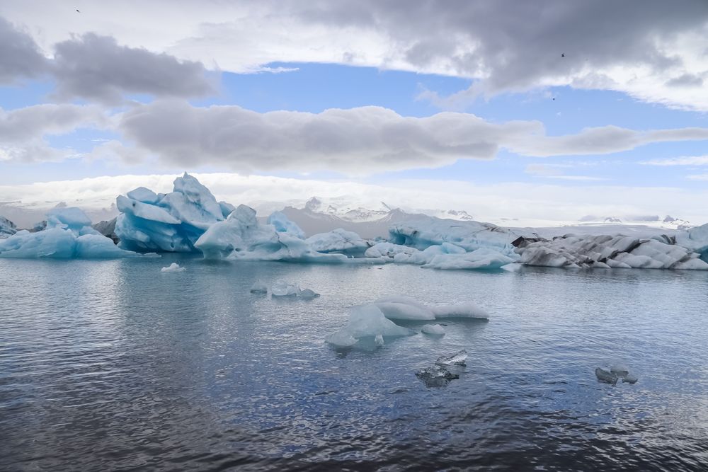 Icebergs floating in jokulsarlon glacier lagoon in iceland under a cloudy sky
