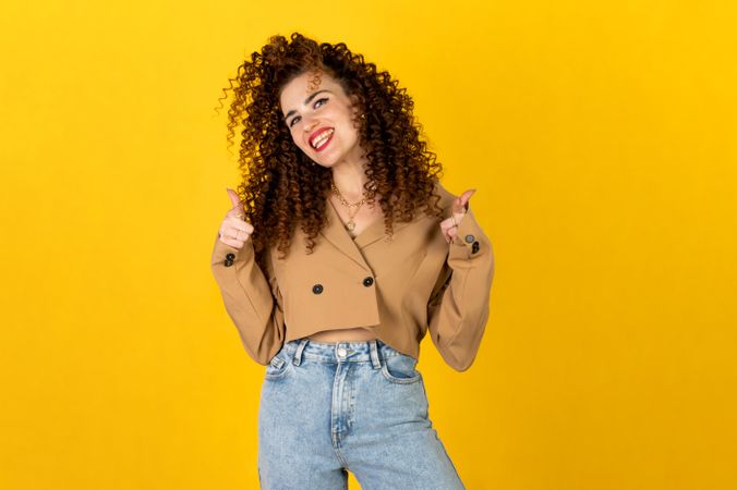 Smiling woman in brown zip up jacket and blue denim jeans