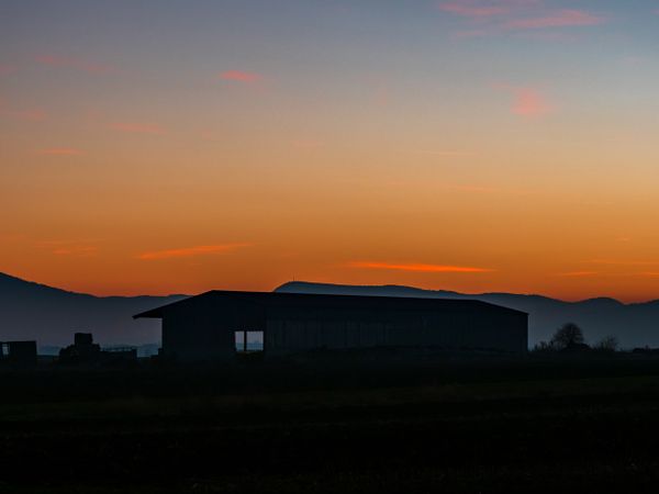 Silhouettes of mountains and colorful amazing sunset in Alsace
