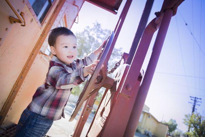 Cute Young Biracial Boy Having Fun on Railroad Car