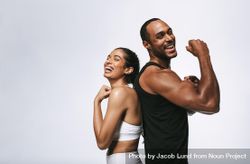 Athletic couple showing off arm muscles standing back to back 5rxxlb