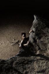 Man practicing rock climbing among large rocks in a forest