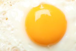 Top view of fried egg, sunny side up in pan, close up