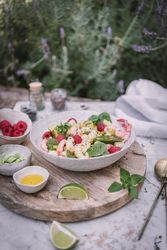 Tasty salad on wooden stand served on decorated table outside