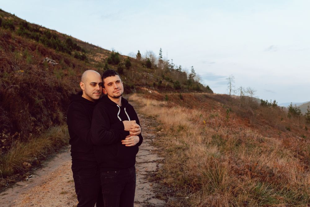Men hugging on road on hill