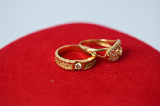 Diamond gold wedding rings on red cloth with copy space