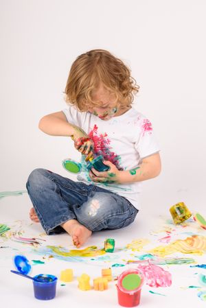 Sloppy boy playing with paints