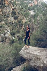 Woman standing on rock near mountains
