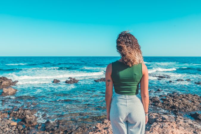 Stylish woman standing near sea