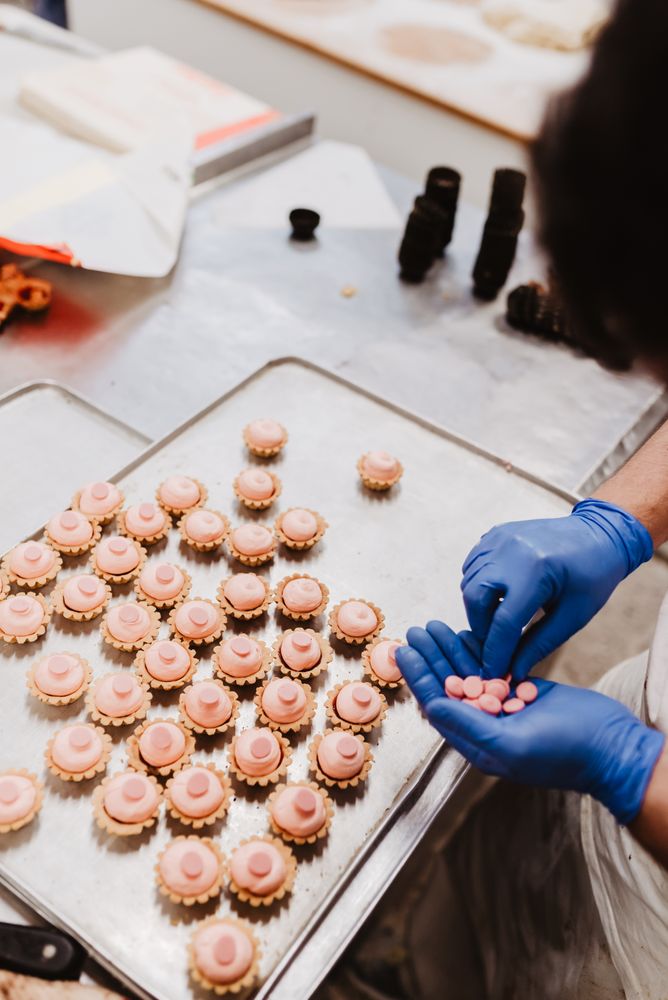 Anonymous baker decorating small cakes