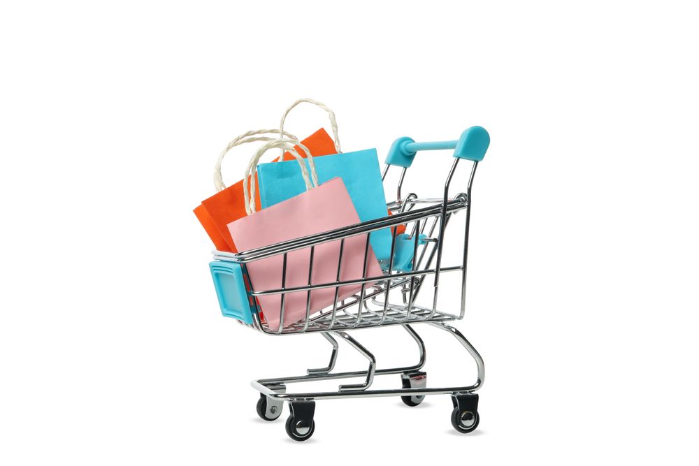 Shop cart with paper bags isolated on light background