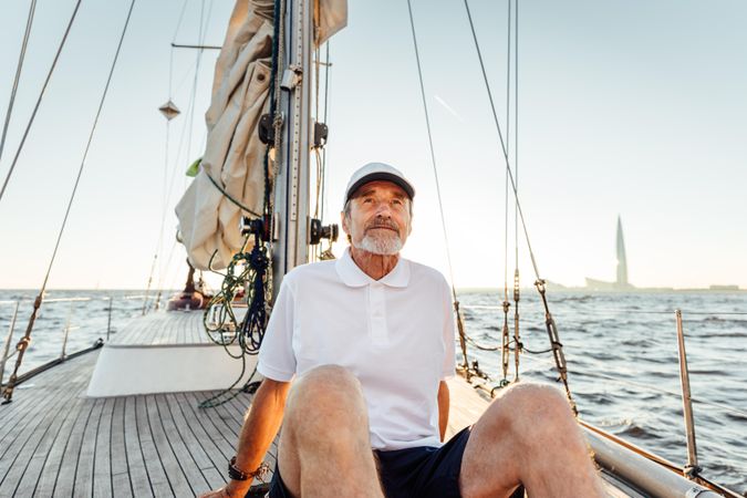 Older man relaxing on sailboat at sunset