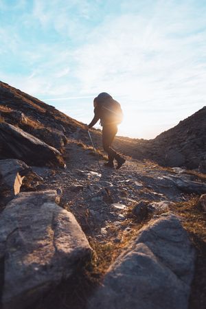 Silhouette of a man with backpack walking in Switzerland at sunrise