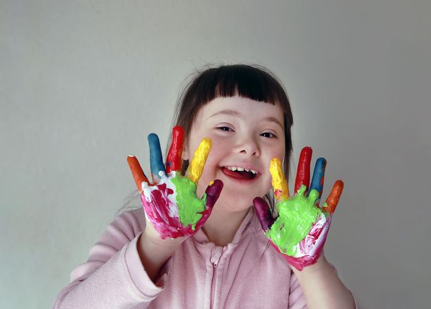 Creative young girl painting with her fingers