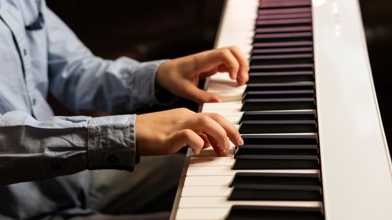 Close-up of child's hands playing the keyboard.