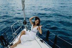 Barefoot bride resting on yacht bow