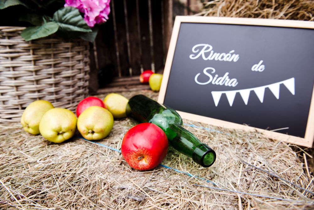 Apples near bottle and sign with inscription on hay