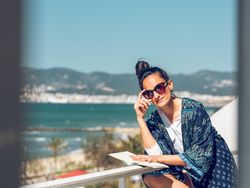 Relaxed woman with book sitting on balcony