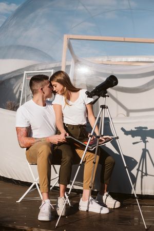 Young couple using astronomical telescope