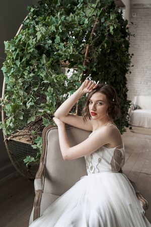woman with red lips in white dress sitting on armchair