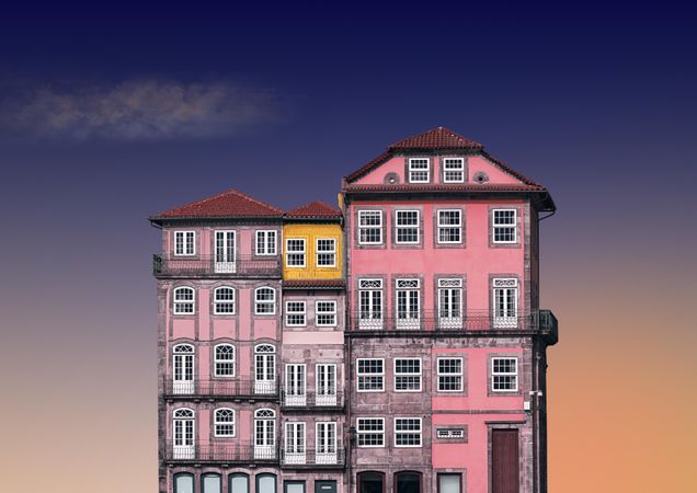 Gradient pink and purple European building against a blue and peach sky