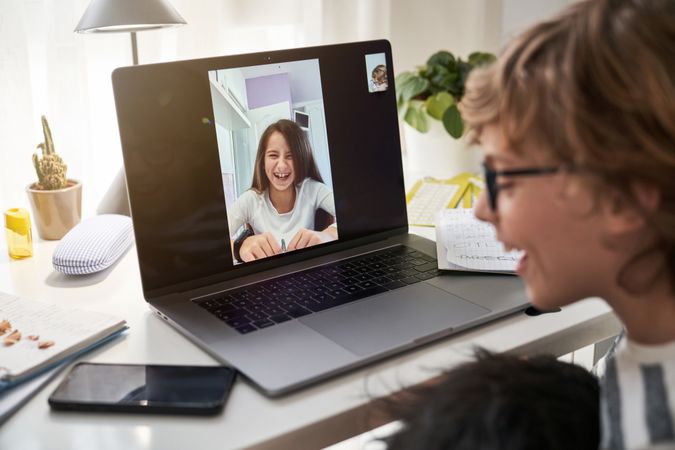Cheerful boy video chatting with classmate